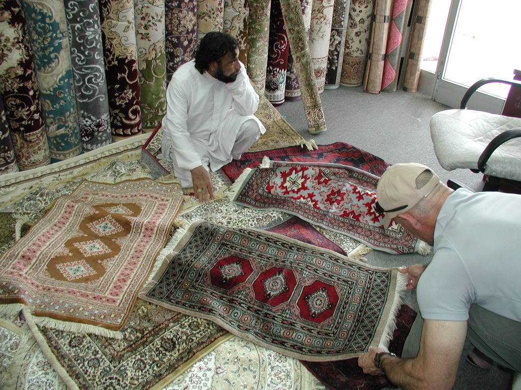 Looking at rugs in Abu Dhabi shop.