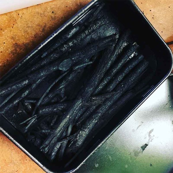 In addition to making bone black, we'll make charcoal sticks. Willow sticks, freshly charred.