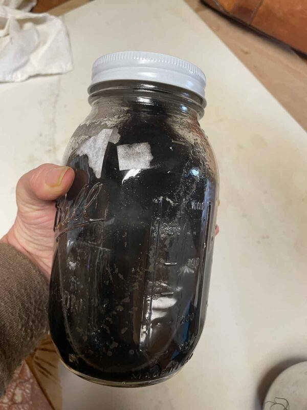 A jar of ground charred bones filled with water to wash the pigment. After pouring this off into other jars, refill and pour off again.
