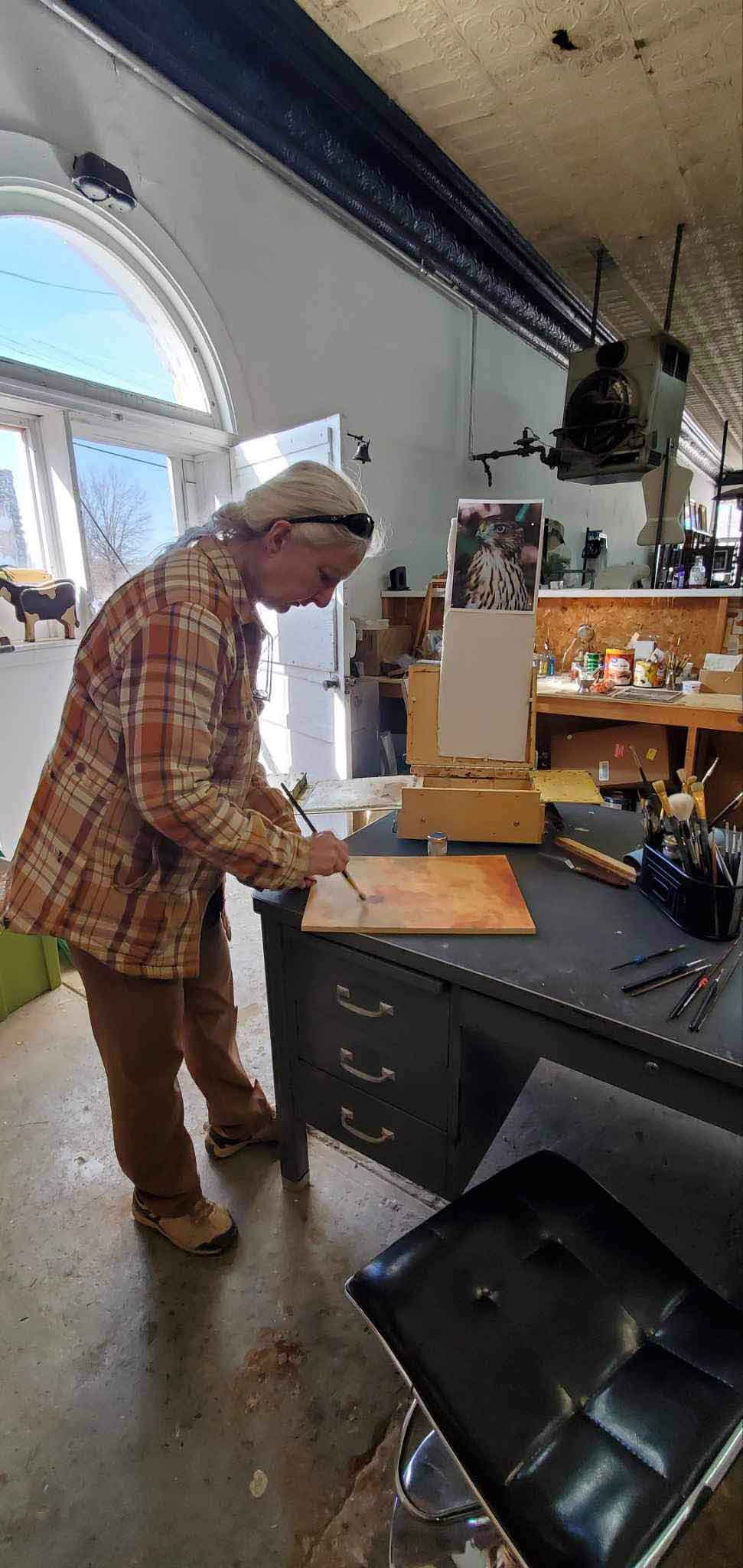 The artist owner painting in the Wild Ozark studio.